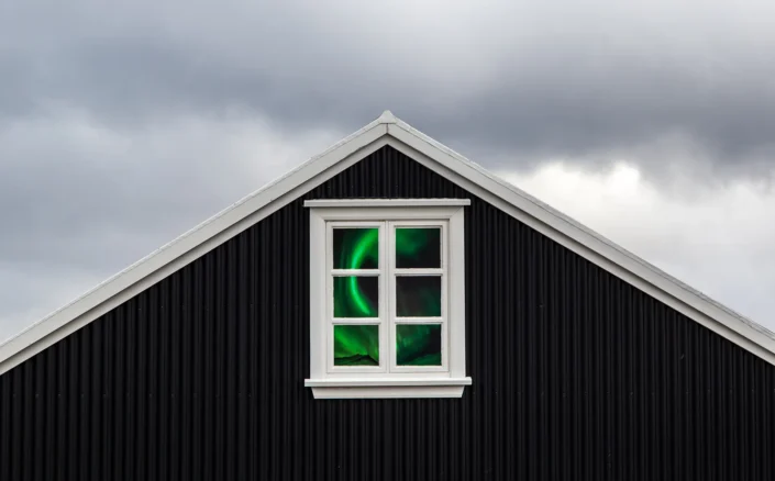 Image d'introduction de la galerie, fausse aurore boréale à travers la fenêtre d'un chalet en Islande
